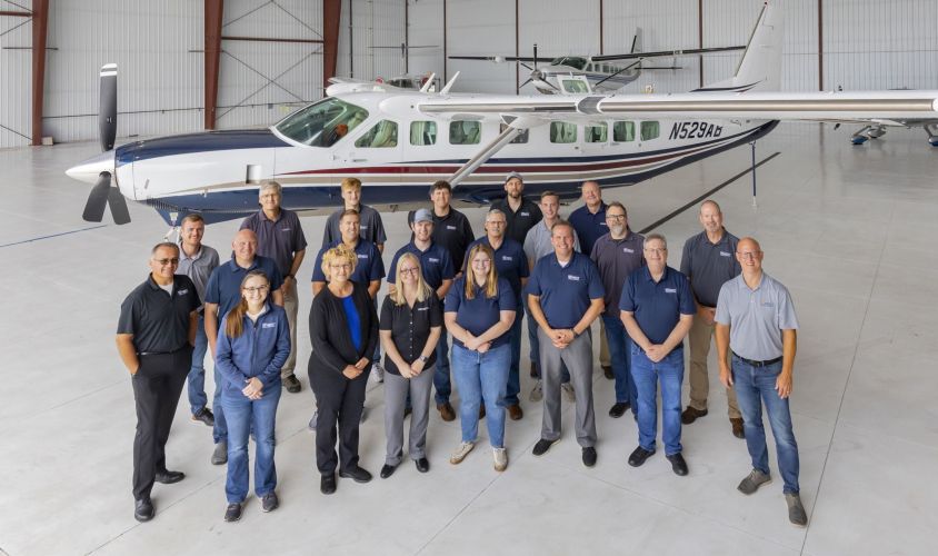 Photo of 95West team and airplane in Grand Forks Airport hanger